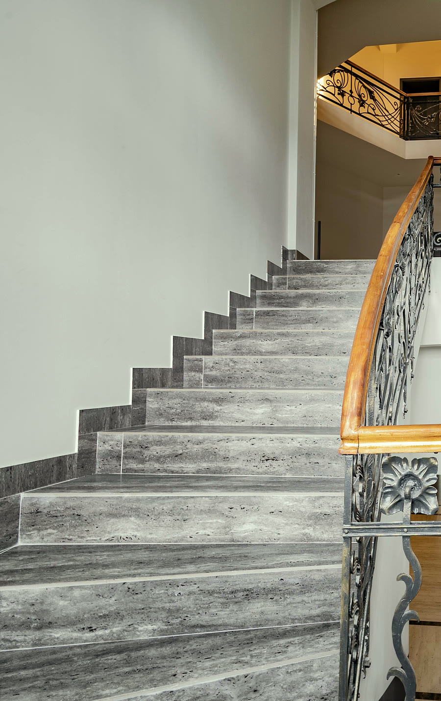 Jugendstil-Treppenhaus mit geschwungenem Holzhandlauf und Steinstufen